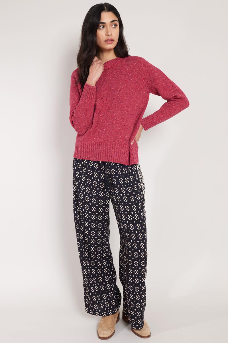 Front view of model wearing East Kaia Trousers, with knitted jumper, hand on hip