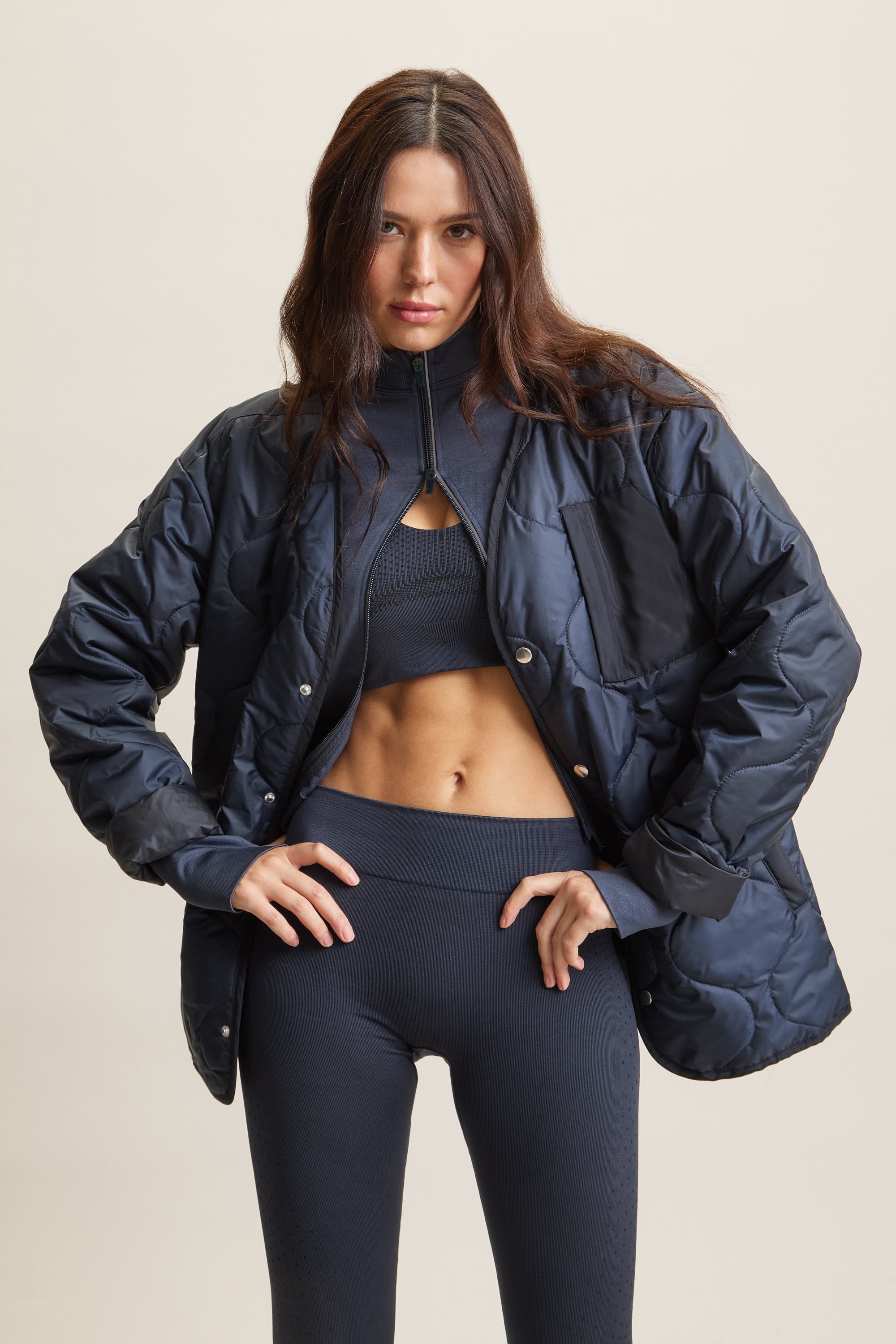 Women's HRMN8 navy dark blue wave-quilted jacket with chest pocket and side pockets, lightweight layering piece for athleisure, streetwear, and activewear. Versatile, breathable, and ideal for transitional weather and everyday movement.