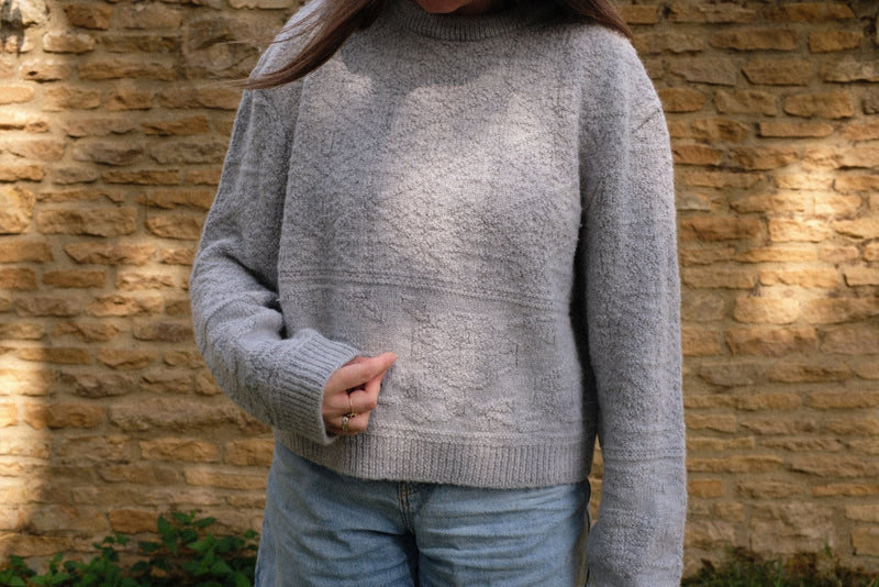 Sustainable knitwear jumper in light grey with textured detail, perfect for everyday wear.