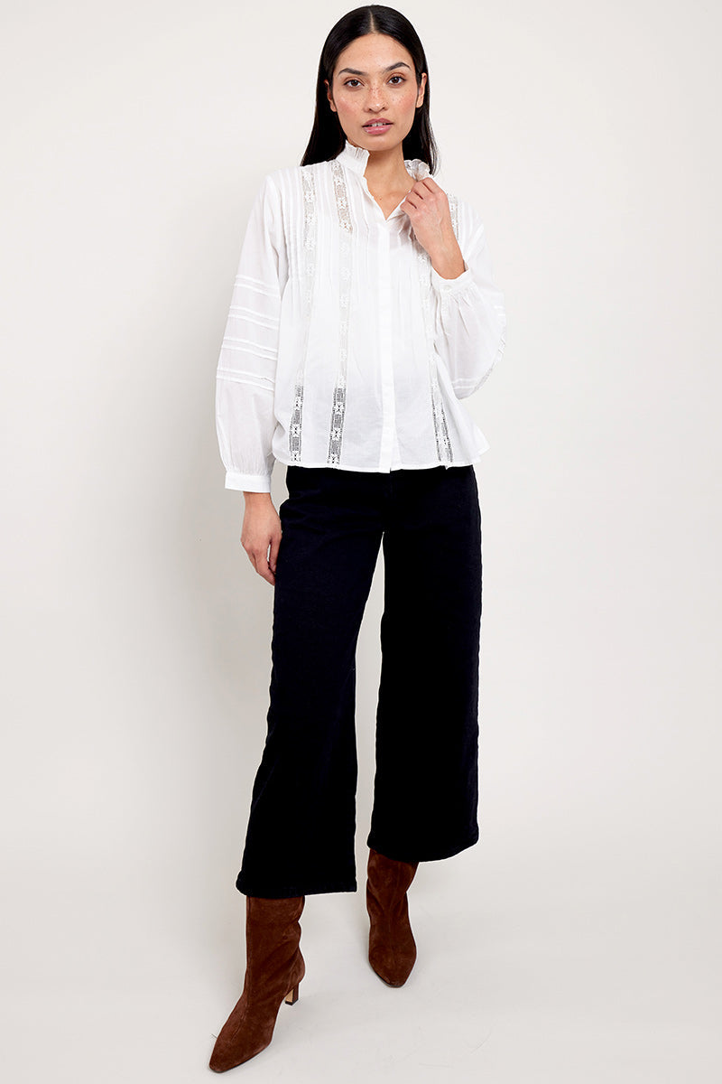 Model wears East Heritage Aashi White blouse, with black wide leg jeans and brown suede boots