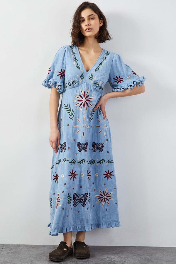 Model wears East Heritage Mererid blue embroidered dress.