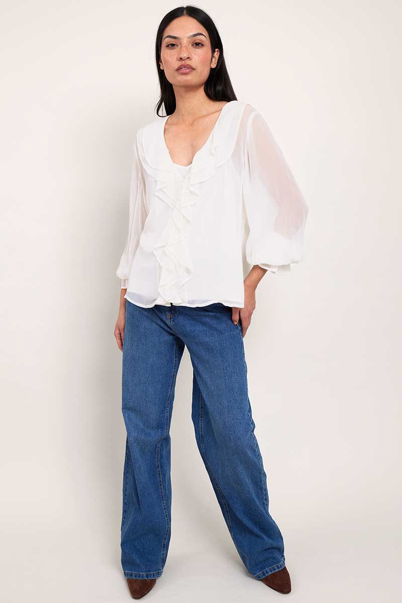 Model wears East Heritage Nuan White ruffle neck blouse.