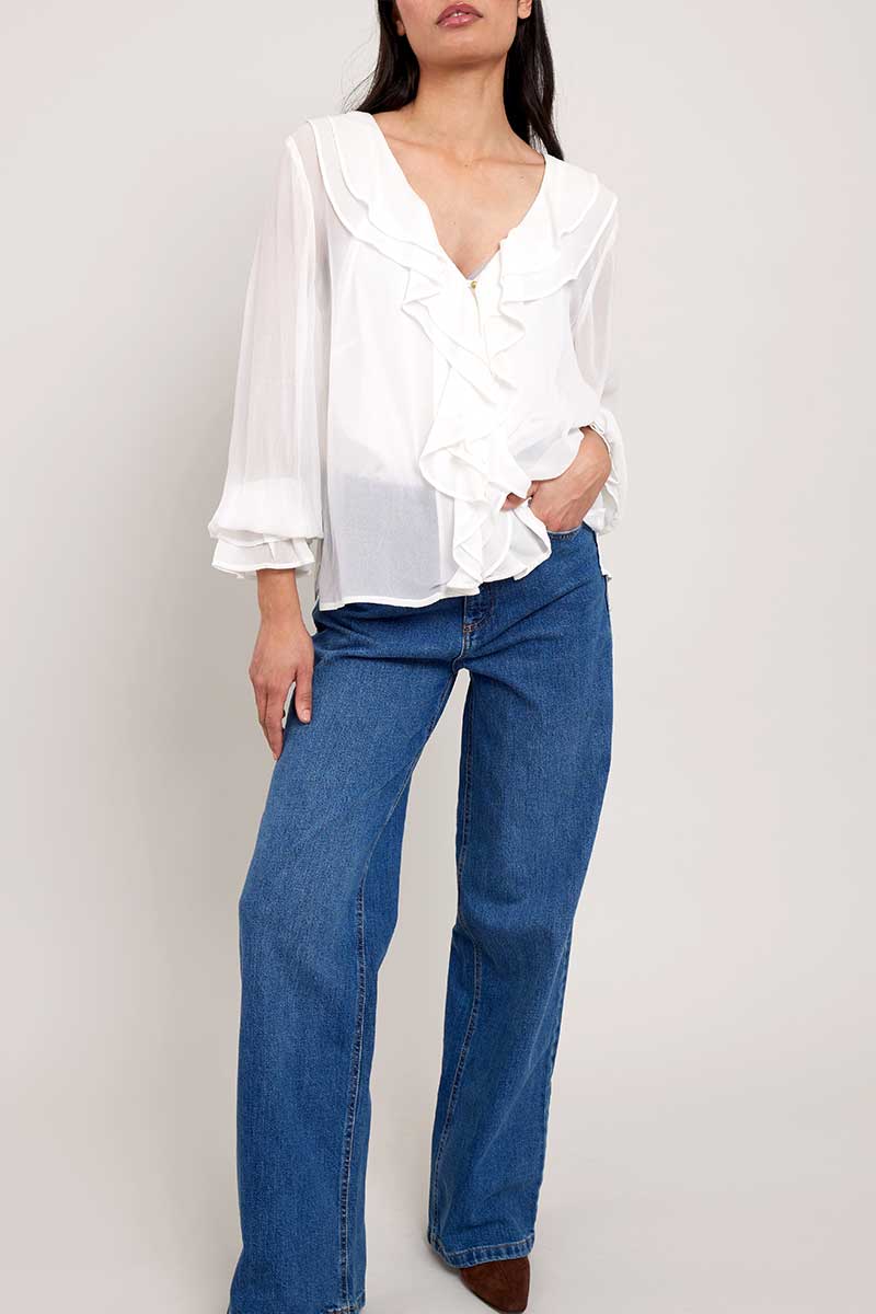 Model wears East Heritage Nuan White ruffle neck blouse.