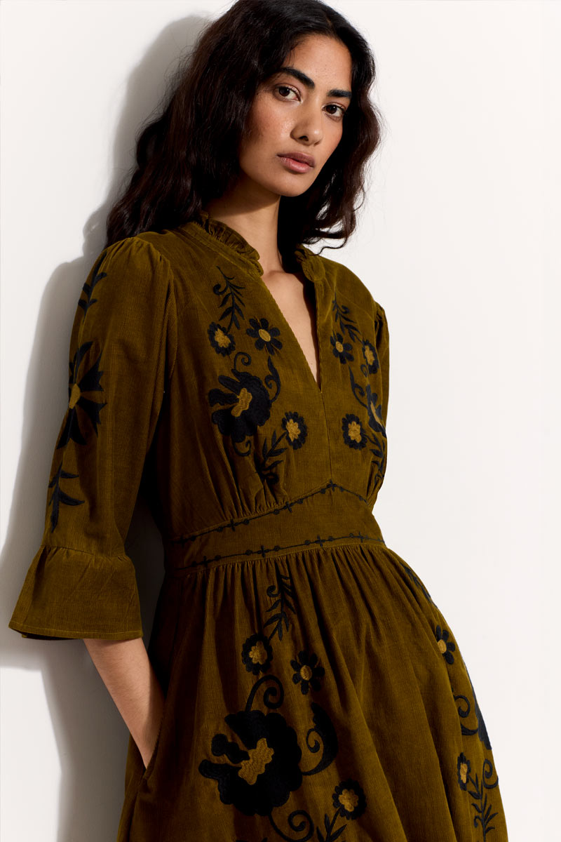 Model wears East Odelia  olive cord embroidered dress.