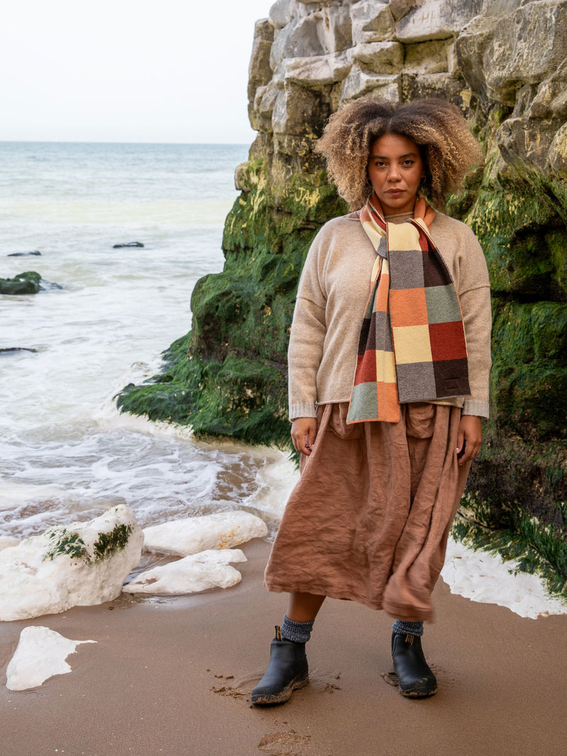 Model Wears British Made Merino Chequerboard Pattern Unisex Scarf in Salmon, Light Green, Rust Red, Vole, Light Yellow & Dark Brown