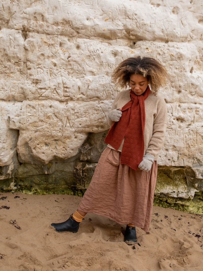 Model wears British Made 100% Merino Wool Unisex Garter Sitch Scarf in Rust and Fingerless Gloves in Natural