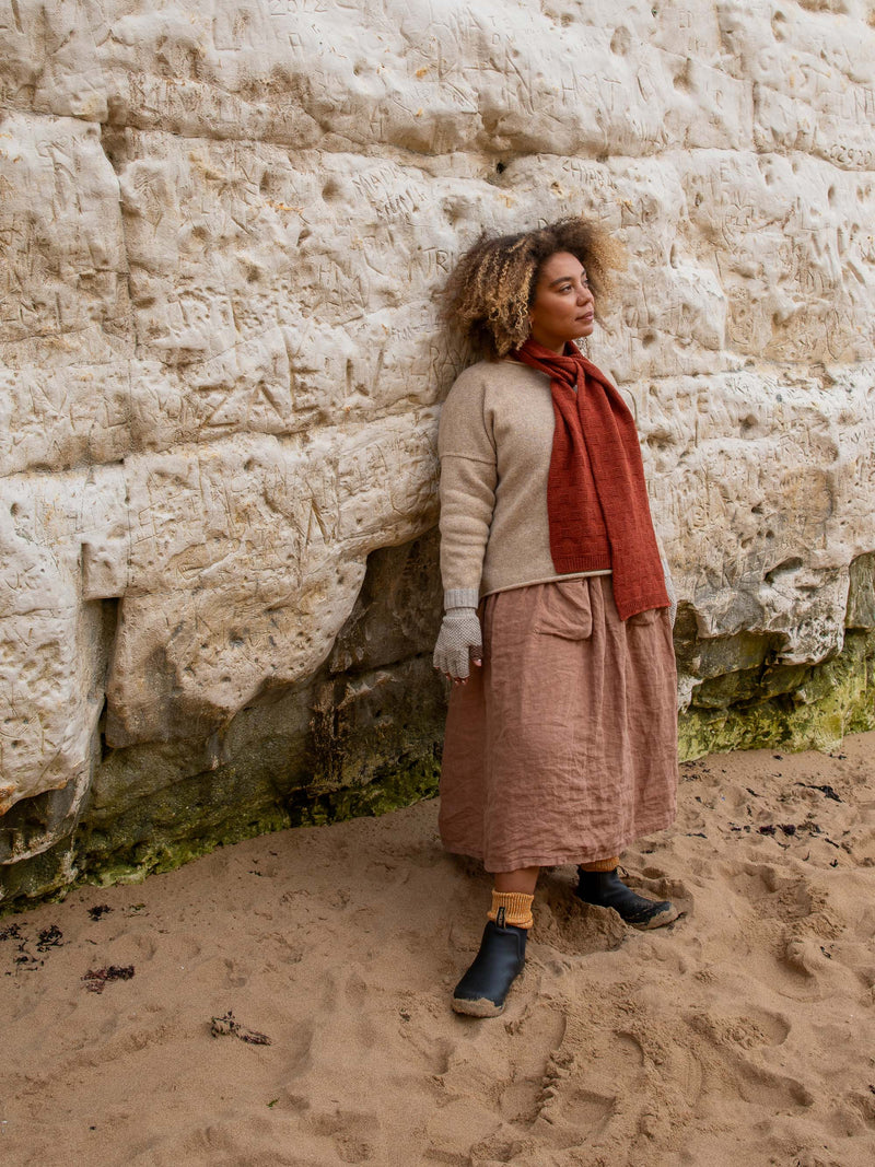 Model wears British Made Unisex 100% Merino Wool Unisex Garter Sitch Scarf in Rust and Fingerless Gloves in Natural