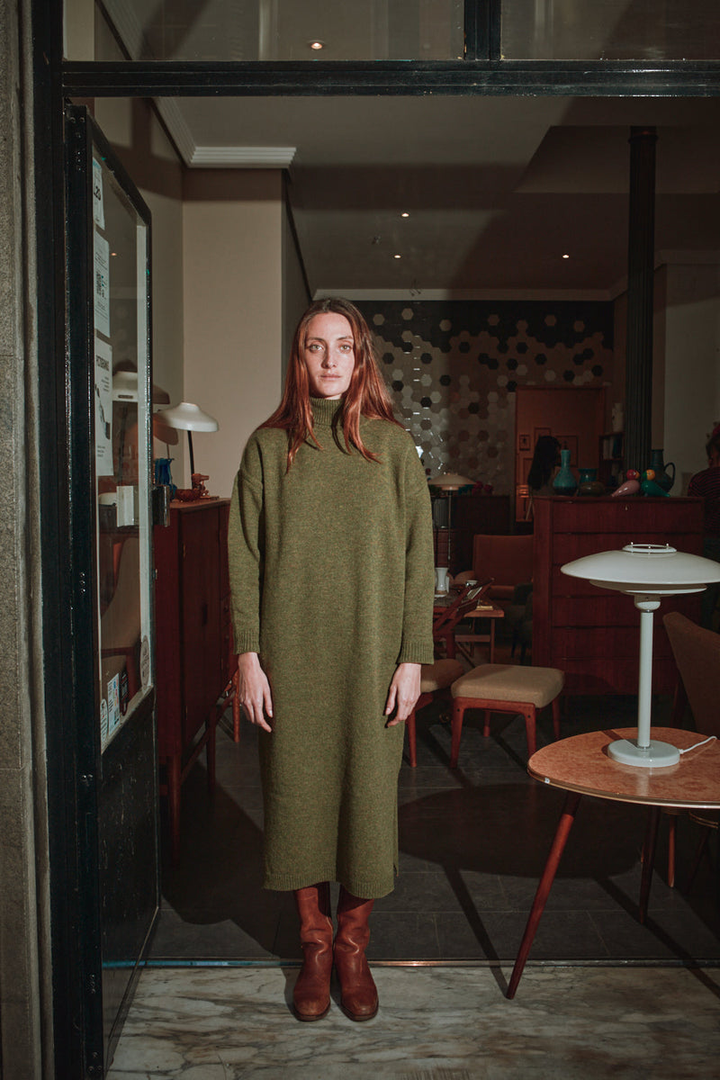 Woman in a green dress standing in a restaurant interior