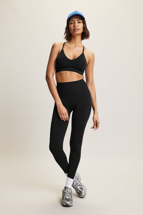 High-waisted black seamless sculpting leggings for women in eco-friendly fabric, perfect for athleisure, activewear, and yoga. Moisture-wicking and squat-proof design ideal for performance, workout, and fitness activities. Fashionable, figure-hugging leggings offering tummy control and breathable comfort, crafted from sustainable materials for versatile all-day wear.