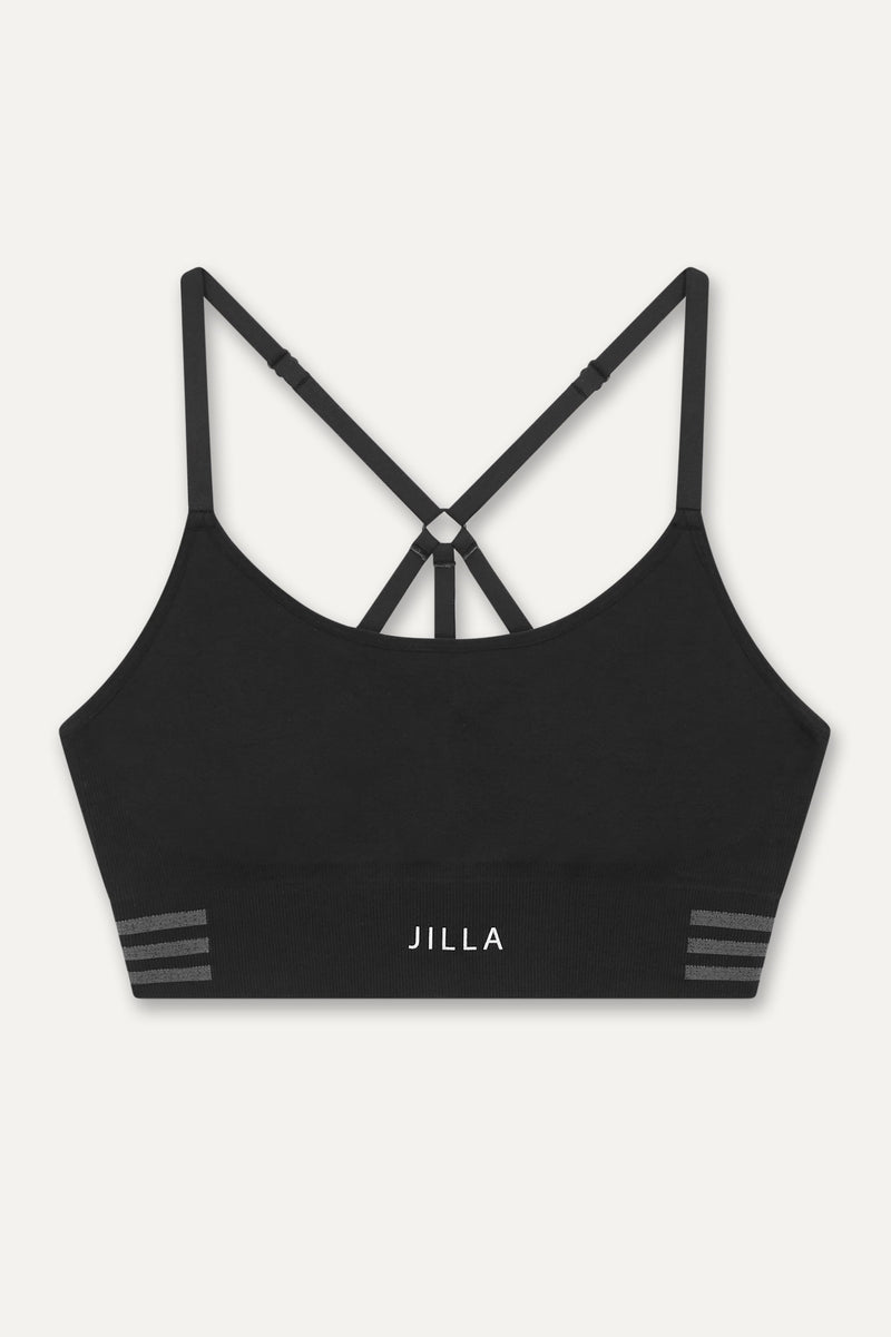 Meet our new black Tone & Lift Recycled Sports Bra! Crafted for comfort and functionality, it's perfect for your active lifestyle. Made with sweat-wicking fabric and adjustable straps, it offers support and adaptability. With stylish details and light to medium support, it's ideal for yoga, pilates, and beyond. Elevate your workout with sustainable style by Jilla Active