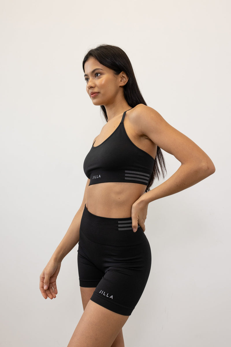 Introducing our black Tone & Lift Recycled Shorts: Your go-to for summer workouts! Made with four-way stretch fabric and ribbing panels, they offer a flattering fit for any activity. Featuring a high-rise ribbed waistband and 5" inseam, they ensure comfort and style. With contrasting colors and internal elastic, they're both fashionable and functional. Pair with our matching bra and Sky's The Limit Oversized T-shirt for a complete look. Sustainable activewear by Jilla Active
