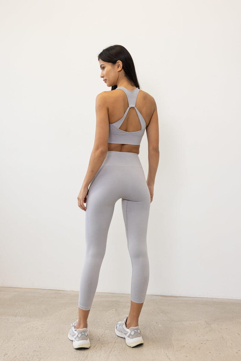 Our light grey Aquarius Recycled Leggings - crafted for seamless performance in your yoga flows, barre workouts, and reformer classes. Made from four-way stretch fabric, they move effortlessly with you. Designed with flattering ribbing and an acid wash effect, each pair is unique. The high-rise ribbed waistband with internal elastic ensures they stay in place during your entire class, while the double-layered gusset provides all-day comfort and flexibility. Elevate your activewear game with Jilla Active