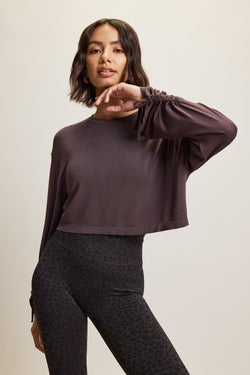 Jilla Active Glide Bamboo black grey cropped, loose-fit long sleeve activewear top in navy blue, made from soft bamboo fabric, with adjustable sleeve ties for a customizable fit. Paired with matching navy leopard-print leggings. Ideal for gym, lounge, pilates, yoga or any activity. 