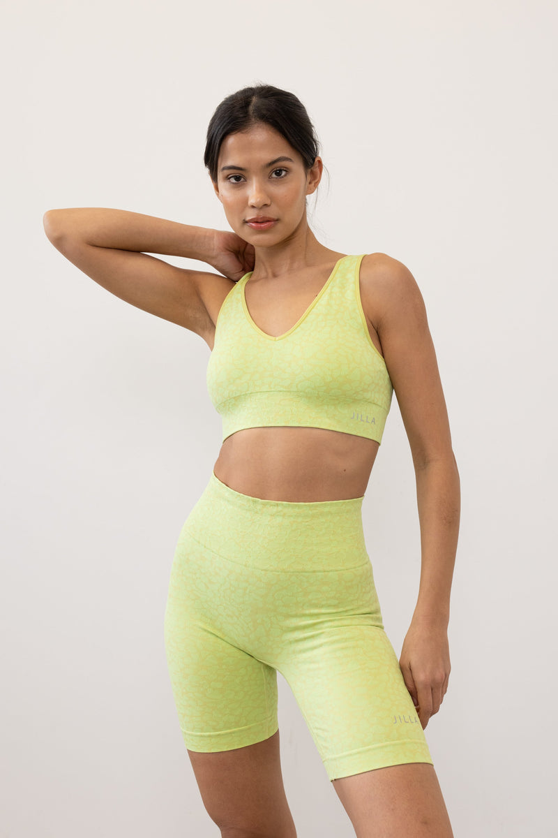 Prepare for summer with our Sahara Recycled Shorts in lime acid green, seamlessly knitted in our new animal jacquard. With a wide ribbed waistband and a mid-thigh finish, they're perfect for studio classes, gym workouts, and everyday style. The internal waistband elastic and four-way stretch fabric ensure they stay in place all day. Complete your look by pairing them with the matching bra and oversized tee from sustainable activewear brand Jilla Active