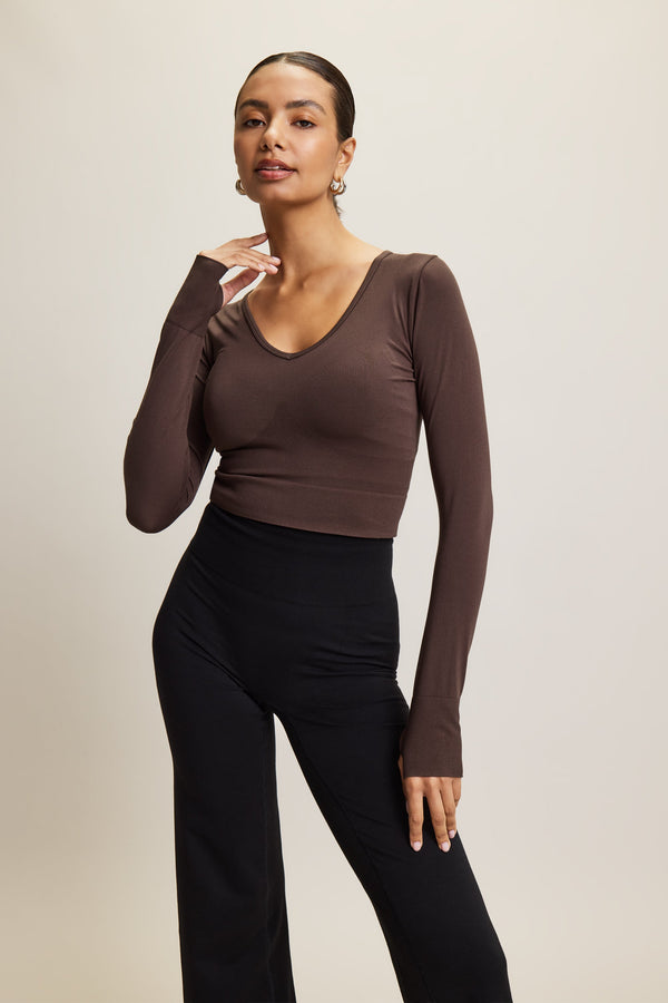 brown stylish cropped long-sleeve athleisure top made from eco-friendly bamboo fabric, featuring a flattering V-neckline, thumbholes for added comfort, and contouring panels for a sculpted fit. Perfect for activewear, this moisture-wicking and breathable top is ideal for workouts, yoga, and casual everyday outfits.