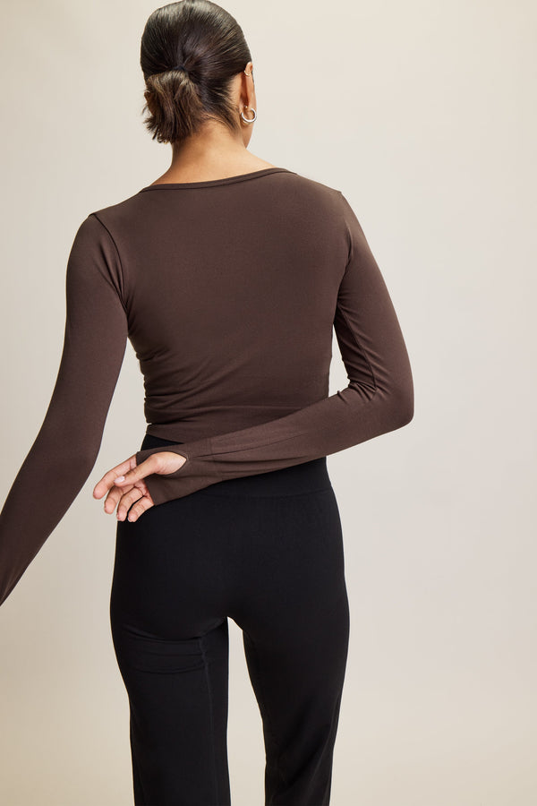 brown stylish cropped long-sleeve athleisure top made from eco-friendly bamboo fabric, featuring a flattering V-neckline, thumbholes for added comfort, and contouring panels for a sculpted fit. Perfect for activewear, this moisture-wicking and breathable top is ideal for workouts, yoga, and casual everyday outfits.