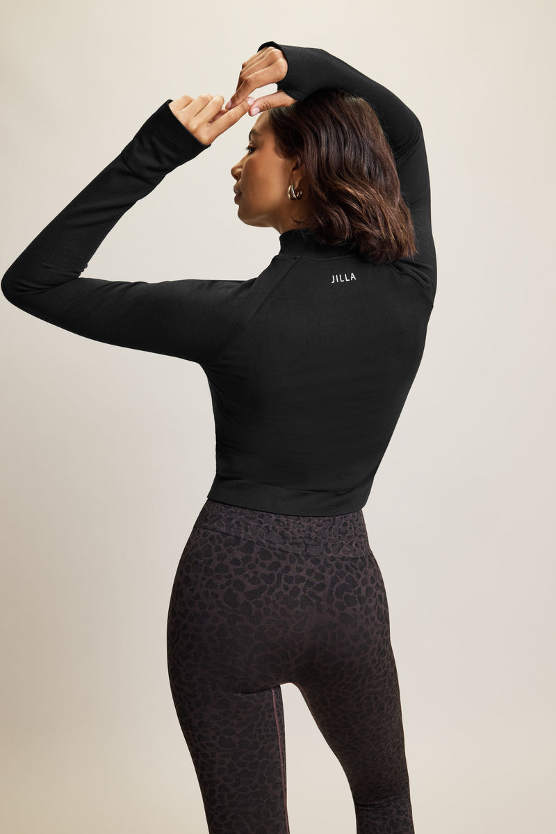 Jilla Active Black Explore cropped, long sleeve bamboo modal thermo top featuring a high neck, half-zip front, and thumbholes. Designed for temperature control during workouts and made from breathable, moisture-wicking fabric. Perfect for gym sessions, outdoor activities, or casual everyday wear.



