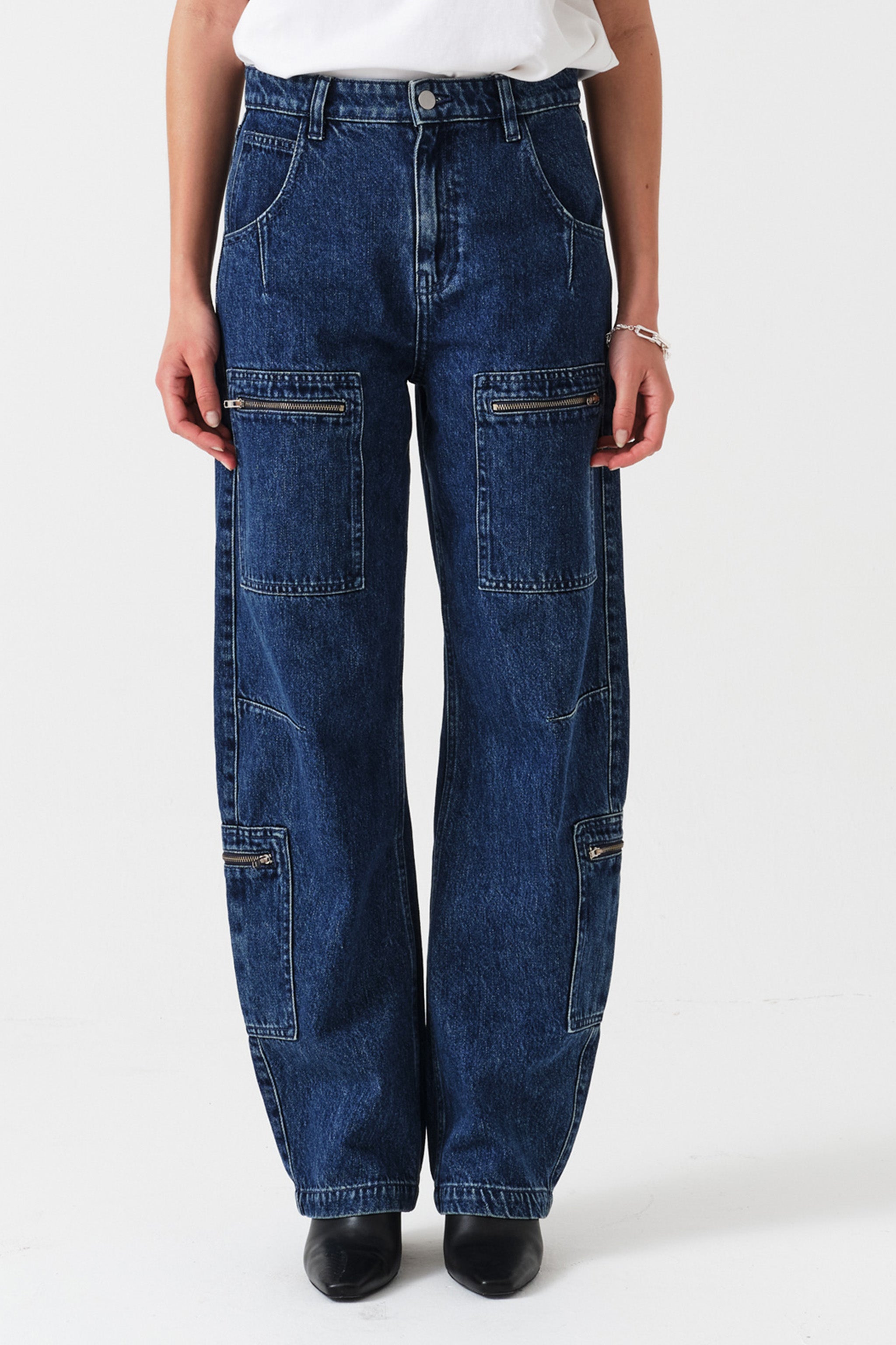 Woman wearing blue jeans with zip details on a white background