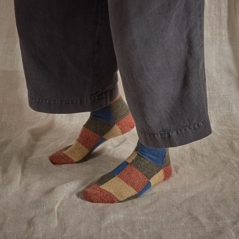 Patchwork marino wool socks in blue, red, natural and grey.