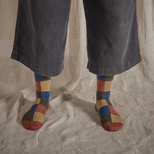 Patchwork marino wool socks in blue, red, natural and grey.