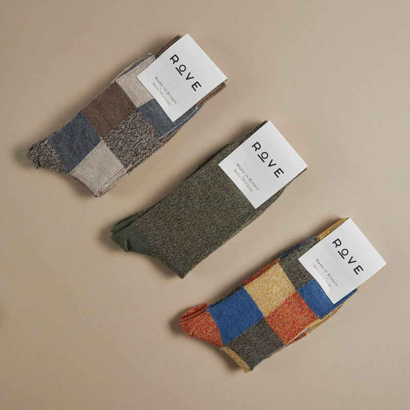 Patchwork marino wool socks in blue, red, natural and grey.