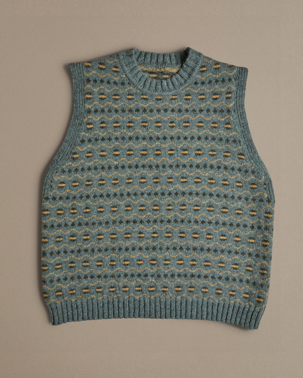 A blue vest with a Fair Isle pattern. Knitted in Scottish spun wool, designed and made in the UK. 