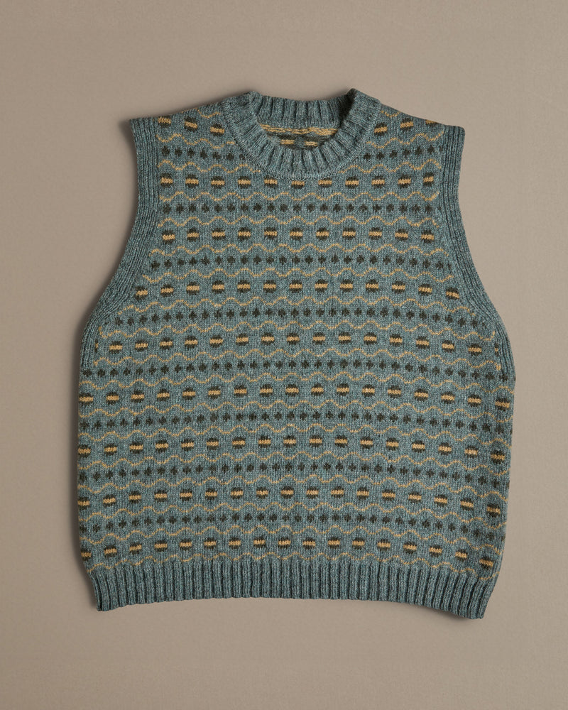 A blue vest with a Fair Isle pattern. Knitted in Scottish spun wool, designed and made in the UK. 