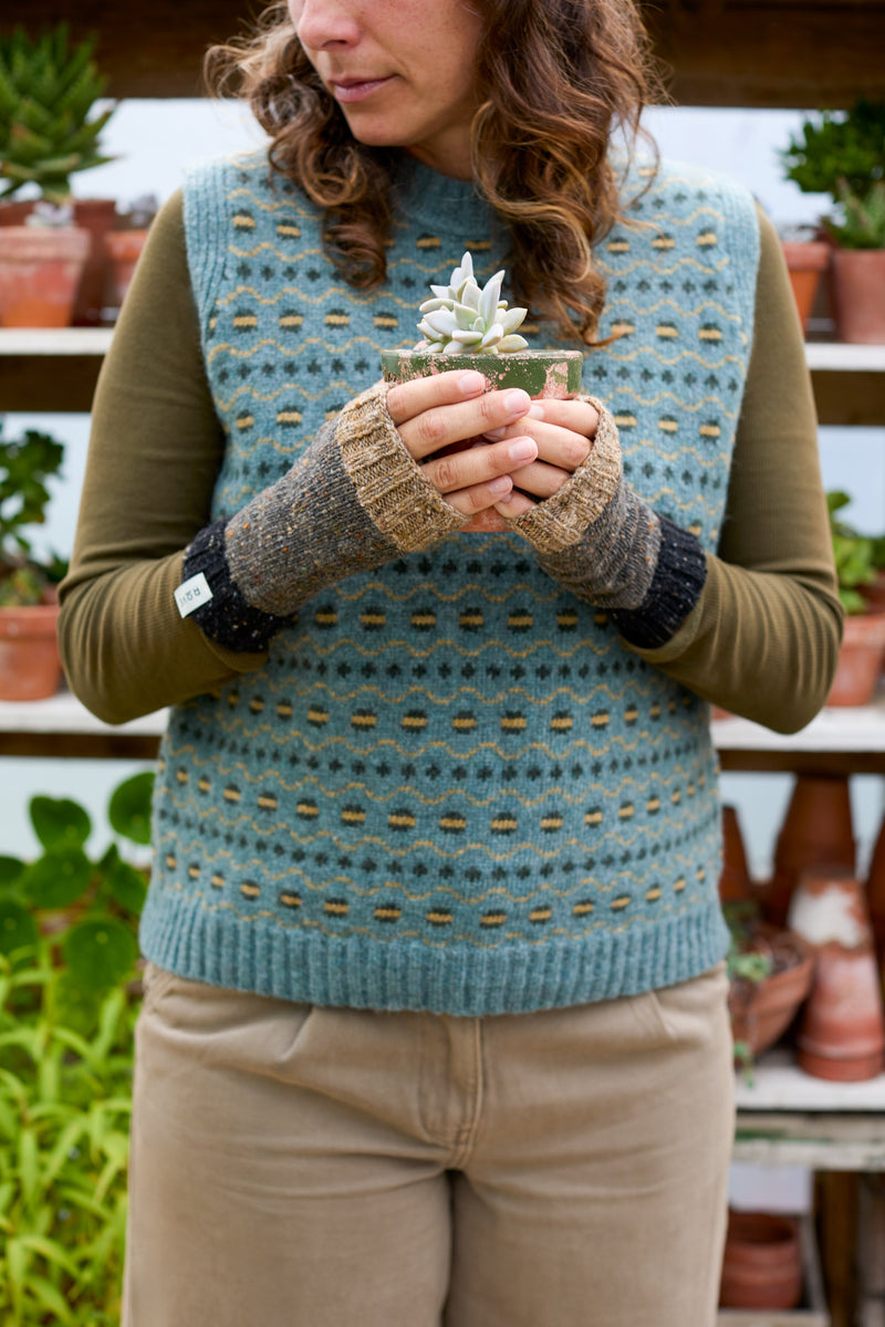 Model wearing a sleeveless fair isle vest in blue. Designed and made in the UK.