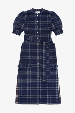 Women's navy check puff sleeve dress, long line with side splits at the hem. The Rosa Dress by Saywood has patch pockets at the hip with ruffles at the bottom of the pockets, with a tied matching belt around the waist. Dress is on a white background.