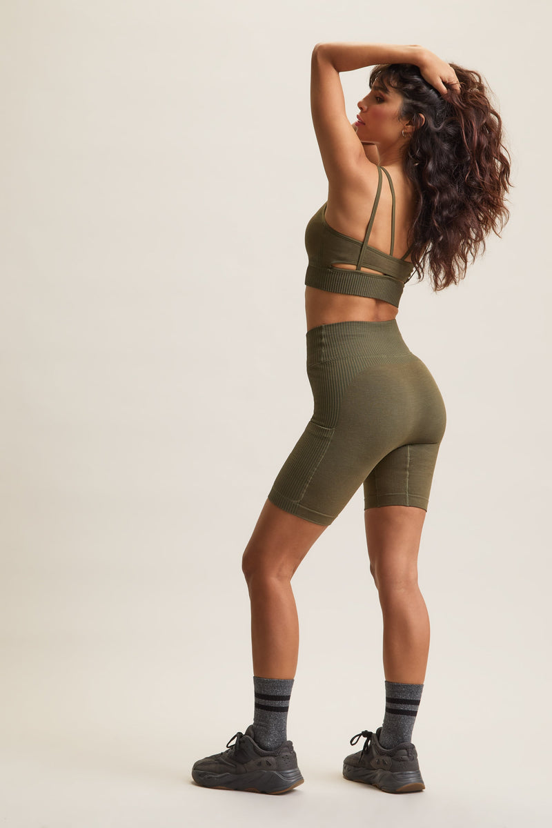 Women's HRMN8 green Venus Block Shorts in a seamless, chunky rib design, featuring a high-waisted crossover waistband for a flattering, sculpted fit. Designed for comfort and style with a supportive, second-skin feel. Includes a side pocket for added convenience. Perfect for athleisure, casual wear, and everyday movement. Pairs with the Venus Rib Bra for a coordinated set.