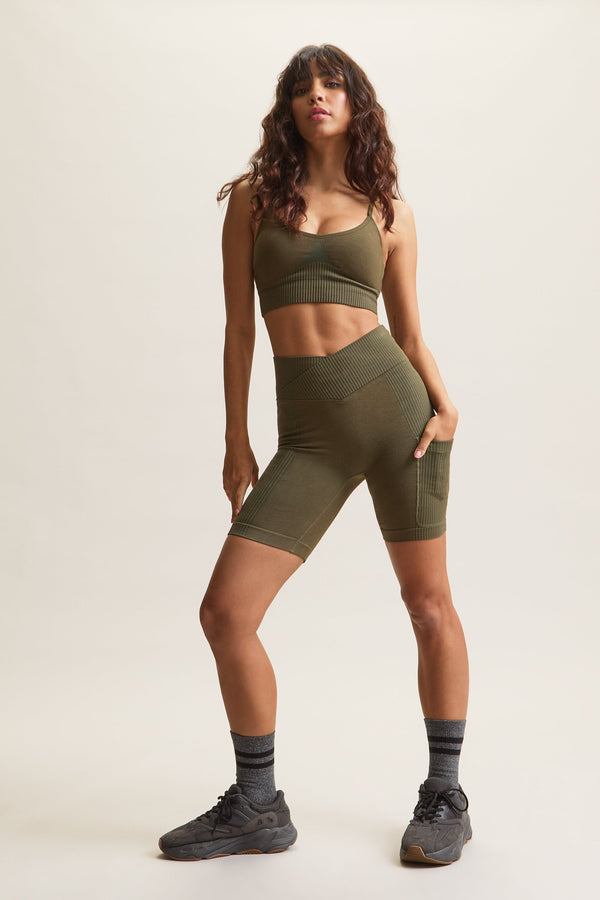 Women's HRMN8 green Venus Block Shorts in a seamless, chunky rib design, featuring a high-waisted crossover waistband for a flattering, sculpted fit. Designed for comfort and style with a supportive, second-skin feel. Includes a side pocket for added convenience. Perfect for athleisure, casual wear, and everyday movement. Pairs with the Venus Rib Bra for a coordinated set.