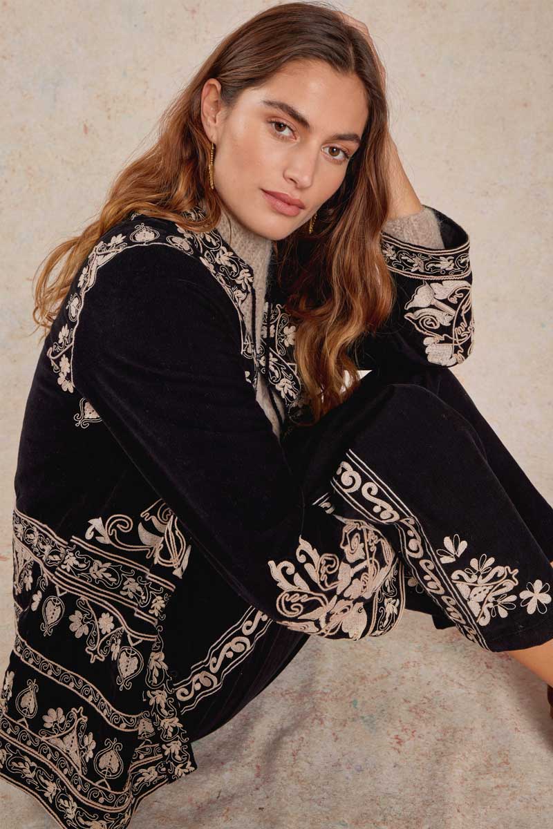 Model wearing Eveline Jacket and trousers, sitting down