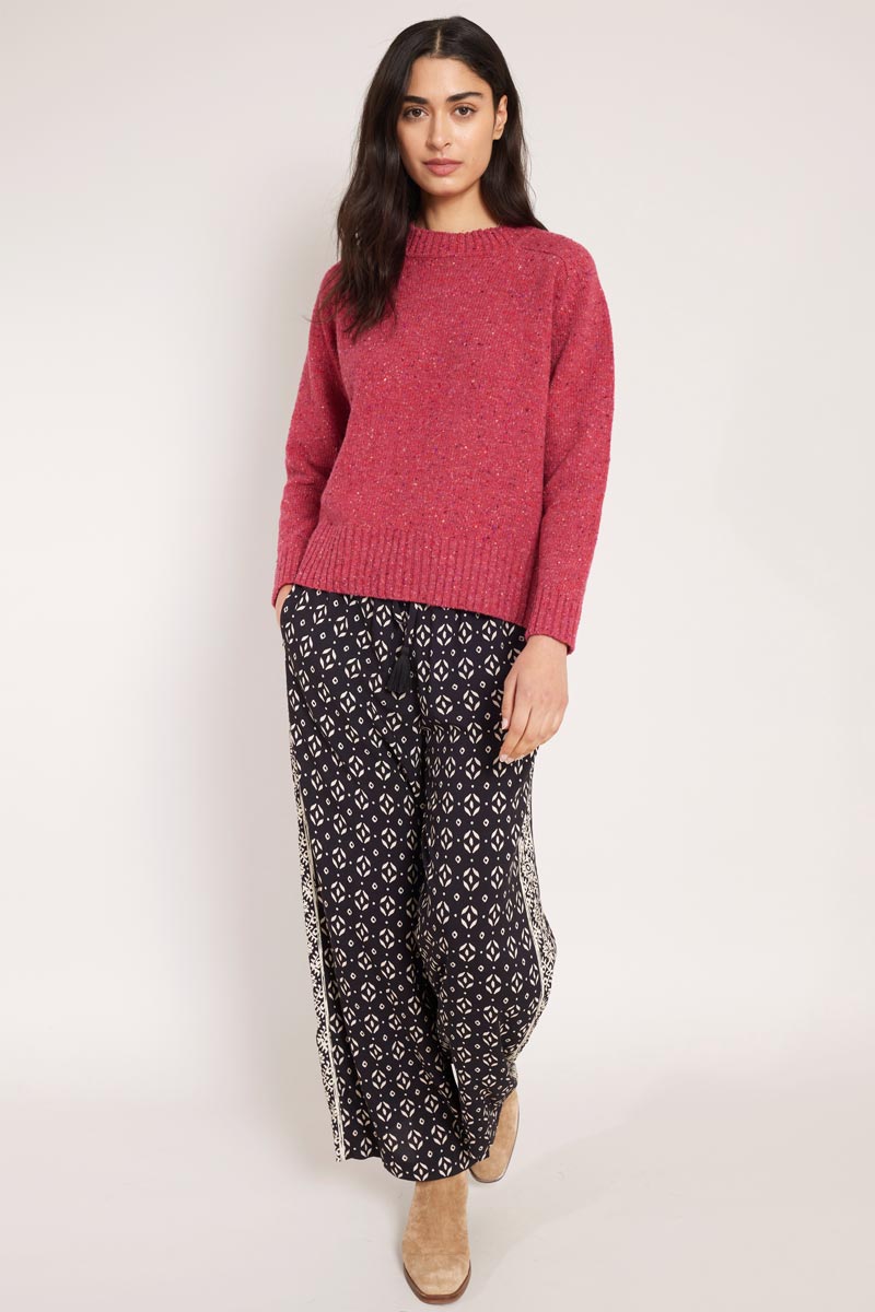 Front view of model wearing East Kaia trousers, with knitted jumper