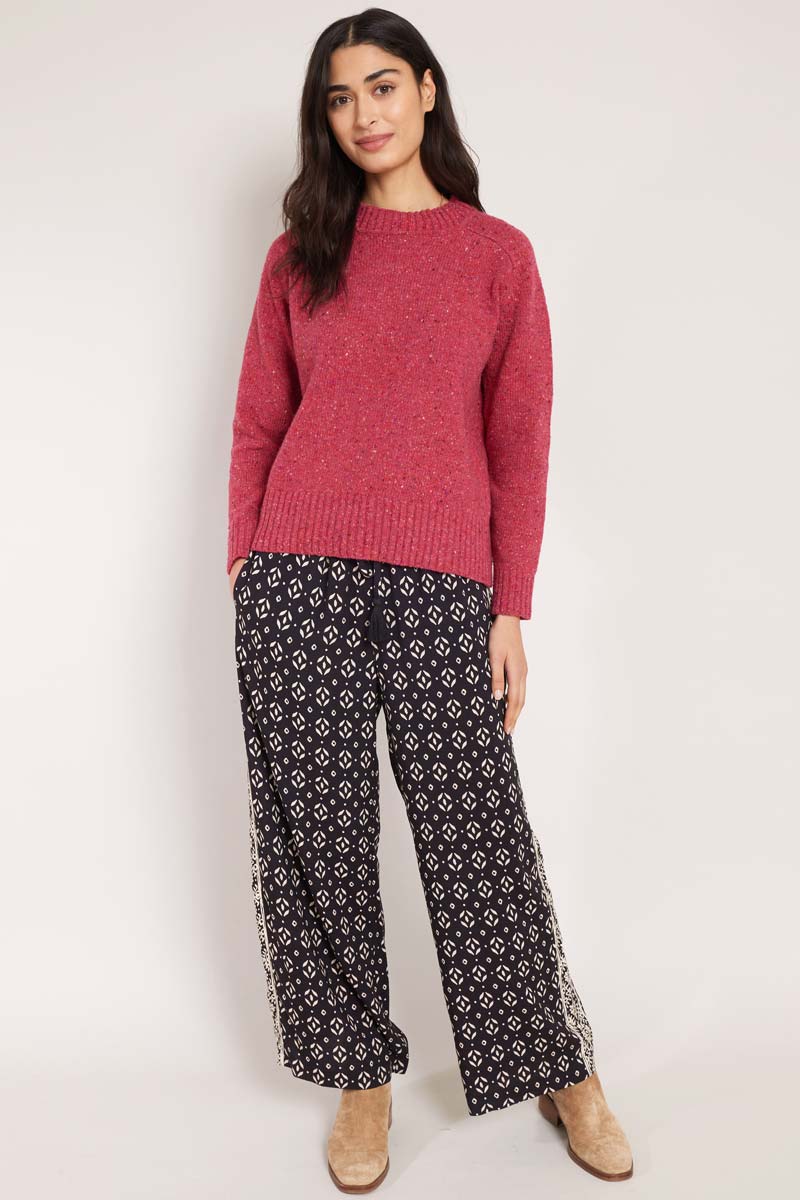Front view of model wearing East Kaia trousers, with knitted jumper