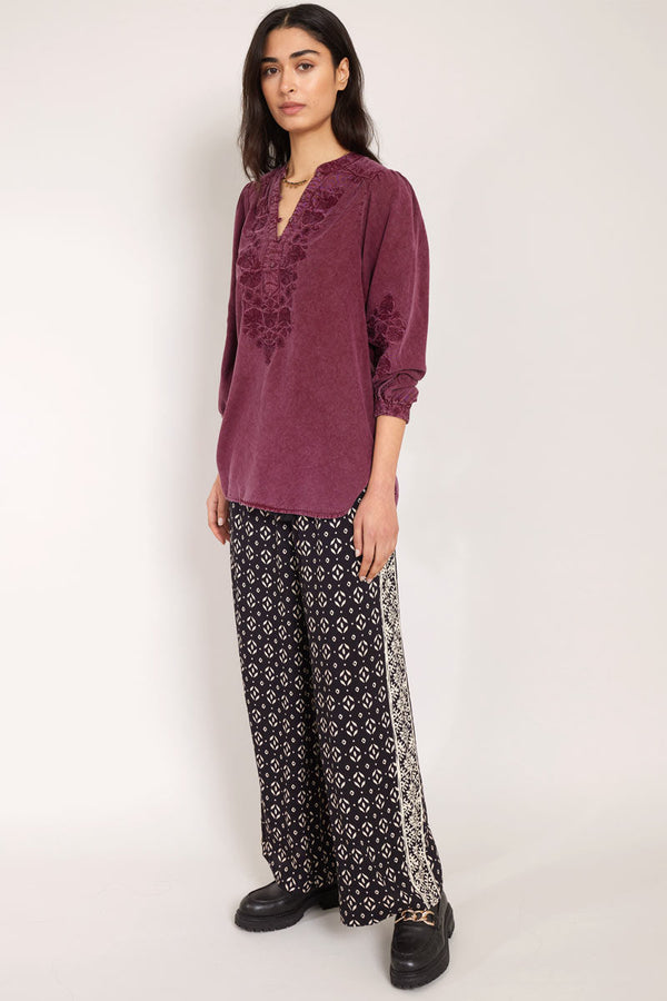 side view of model wearing East Kaia Trousers with embroidered blouse