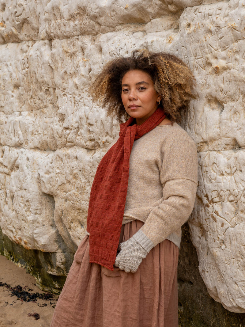 Model wears British Made 100% Merino Wool Unisex Garter Sitch Scarf in Rust and Fingerless Gloves in Natural