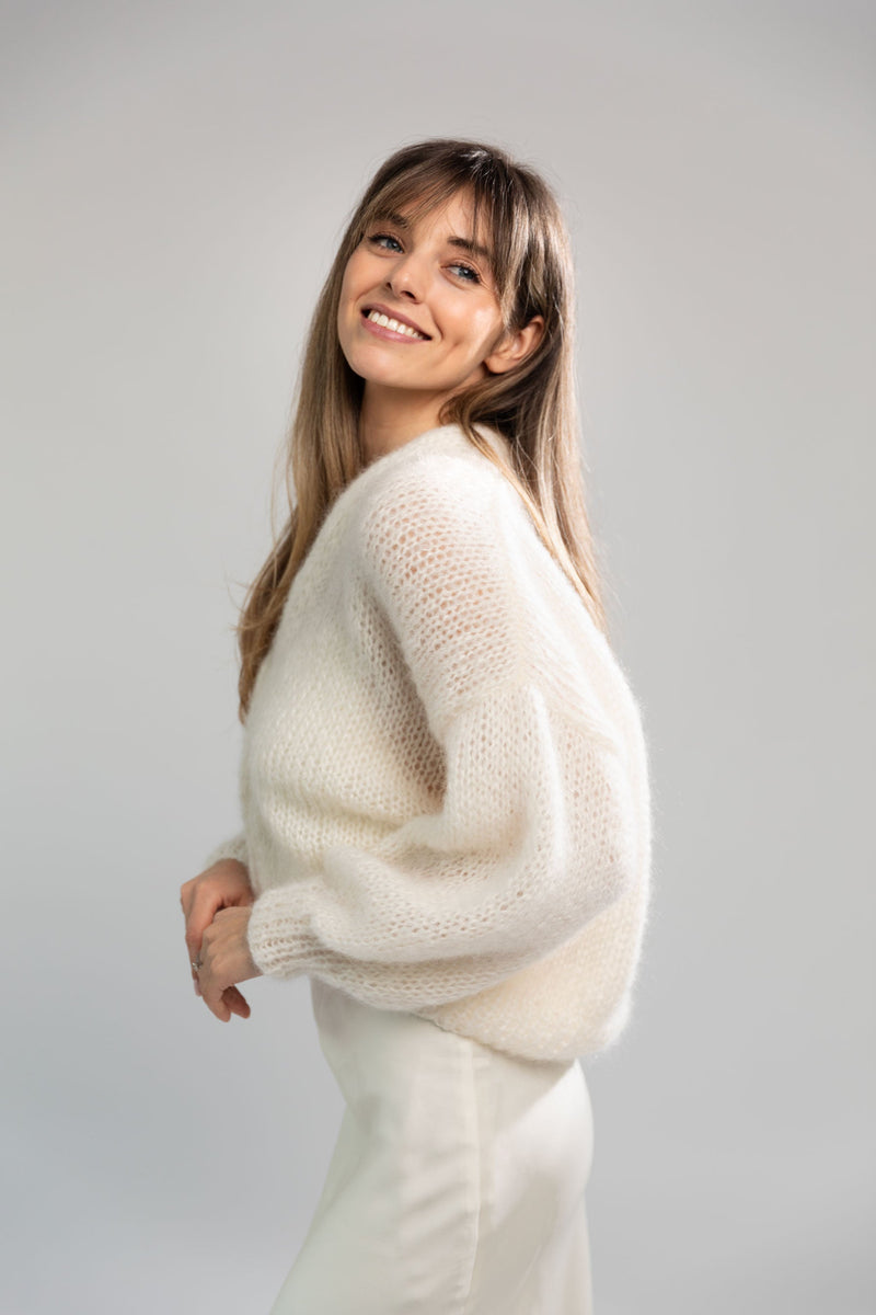 Handmade fluffy mohair cardigan, white color, with dropped shoulders and shell buttons. It has a voluminous and airy texture. Style it with high rise bottoms or a slip dress. Made from premium Italian yarn.